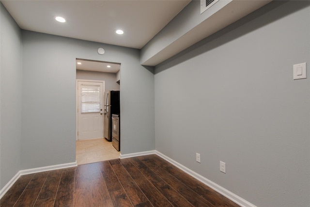 empty room featuring baseboards, recessed lighting, and wood finished floors