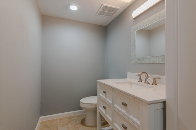 bathroom with tile patterned floors, toilet, vanity, baseboards, and visible vents