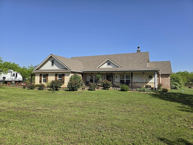 ranch-style house with brick siding, a front lawn, roof with shingles, and a chimney