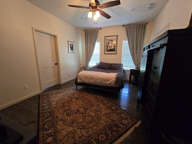 bedroom with baseboards, ceiling fan, dark wood-style floors, and visible vents