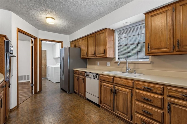 kitchen with a sink, white dishwasher, brown cabinetry, and stainless steel fridge with ice dispenser