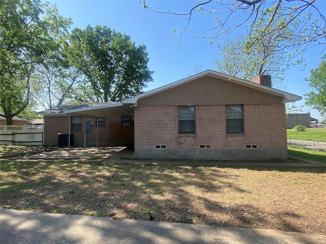 rear view of property with fence, a chimney, crawl space, and brick siding