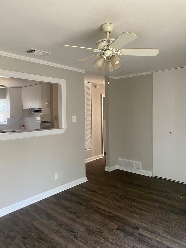 interior space with visible vents, dark wood-type flooring, ceiling fan, and ornamental molding