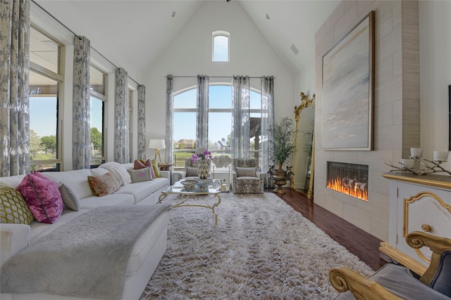 3429 Lochside, The Colony, TX 75056 - living room with a tile fireplace, wood finished floors, and high vaulted ceiling