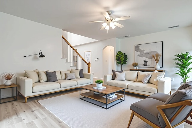 1415 Lowes Farm Pkwy, Mansfield, TX 76063 - living room with arched walkways, light wood-type flooring, ceiling fan, and stairway