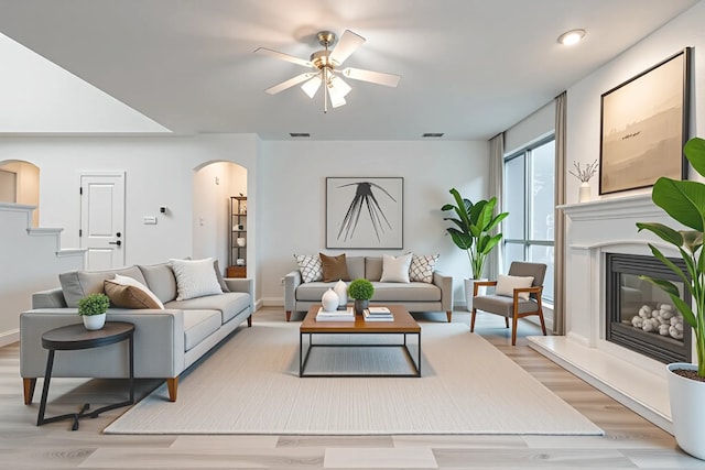 1415 Lowes Farm Pkwy, Mansfield, TX 76063 - living area featuring arched walkways, ceiling fan, a glass covered fireplace, light wood finished floors, and recessed lighting