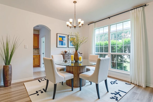 1415 Lowes Farm Pkwy, Mansfield, TX 76063 - dining space with arched walkways, a chandelier, healthy amount of natural light, and light wood-style flooring