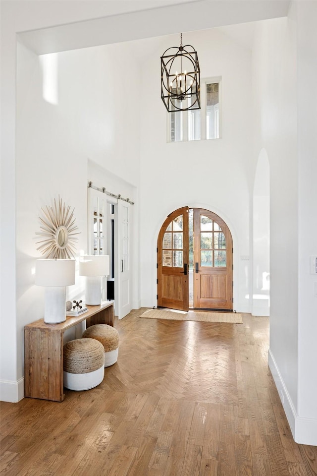 3110 High Rd, Flower Mound, TX 75022 - foyer entrance featuring a chandelier, baseboards, arched walkways, parquet flooring, and a high ceiling