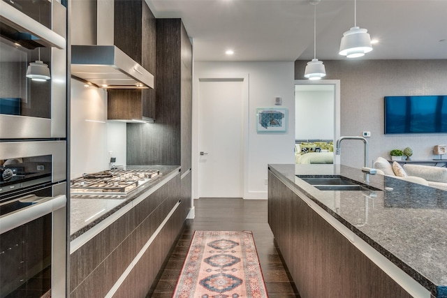 3130 N Harwood St Unit 901, Dallas, TX 75201 - kitchen with wall chimney range hood, dark brown cabinetry, modern cabinets, a sink, and dark wood-style floors