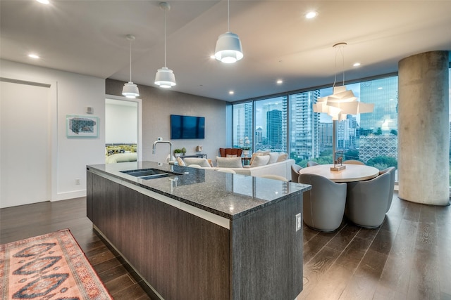 3130 N Harwood St Unit 901, Dallas, TX 75201 - kitchen with a kitchen island with sink, dark wood finished floors, a sink, dark stone countertops, and recessed lighting