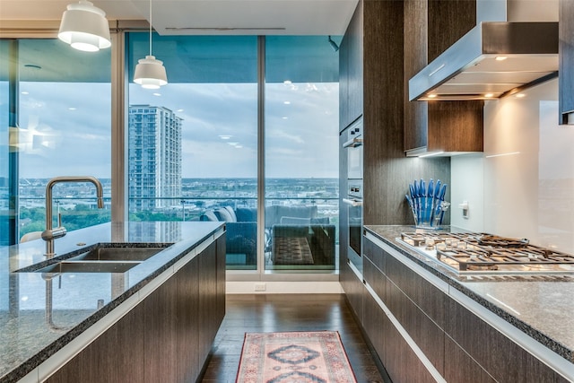 3130 N Harwood St Unit 901, Dallas, TX 75201 - kitchen with exhaust hood, dark brown cabinetry, appliances with stainless steel finishes, a sink, and dark wood-style floors