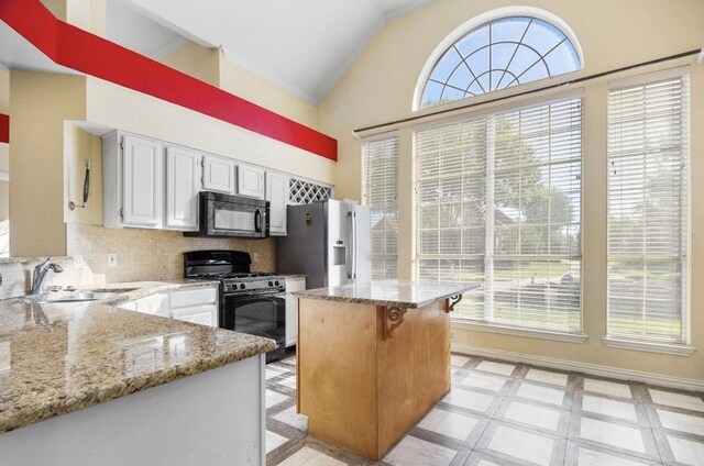 5517 Luna Dr, Rowlett, TX 75088 - kitchen featuring black appliances, a sink, lofted ceiling, and plenty of natural light