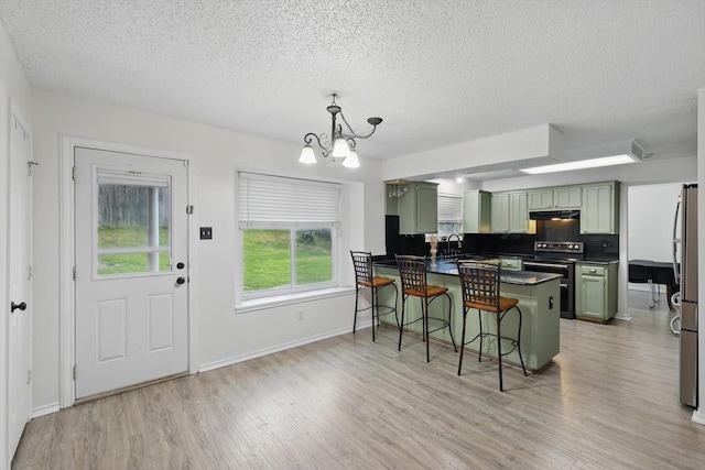 10313 Gray Oak Ln, Fort Worth, TX 76108 - kitchen with a kitchen bar, dark countertops, appliances with stainless steel finishes, green cabinets, and a peninsula