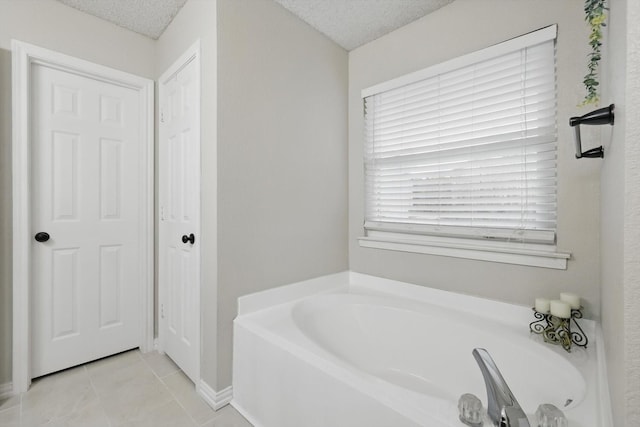 10313 Gray Oak Ln, Fort Worth, TX 76108 - bathroom featuring tile patterned floors, baseboards, a garden tub, and a textured ceiling
