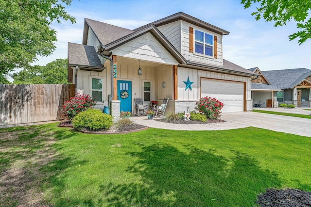 view of front facade featuring a front yard, a garage, driveway, board and batten siding, and fence