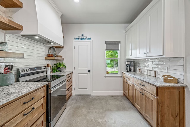 kitchen with stainless steel electric range oven, open shelves, wall chimney range hood, and decorative backsplash
