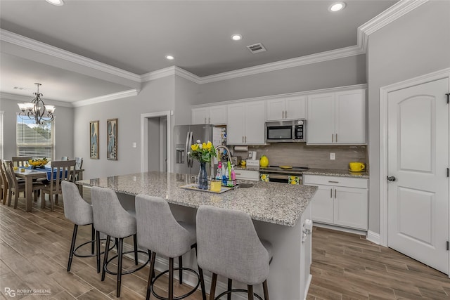 3843 Joseph Randall Dr, Shreveport, LA 71107 - kitchen with appliances with stainless steel finishes, white cabinetry, and an island with sink