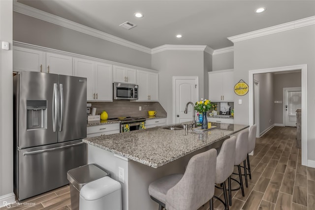 3843 Joseph Randall Dr, Shreveport, LA 71107 - kitchen featuring a sink, visible vents, ornamental molding, wood finish floors, and appliances with stainless steel finishes