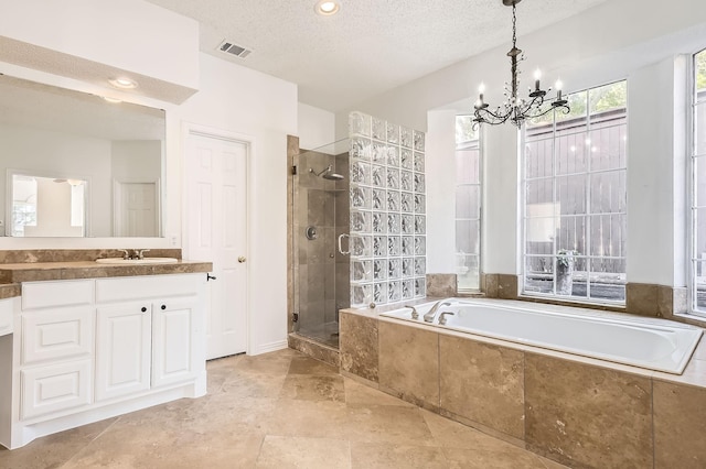 bathroom featuring an inviting chandelier, vanity, a stall shower, visible vents, and a garden tub
