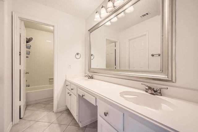 bathroom featuring visible vents, a textured ceiling, and a sink