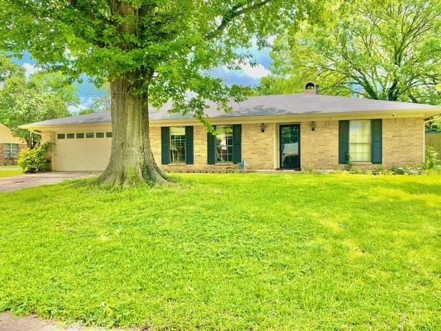 ranch-style home featuring a front lawn, an attached garage, concrete driveway, and brick siding