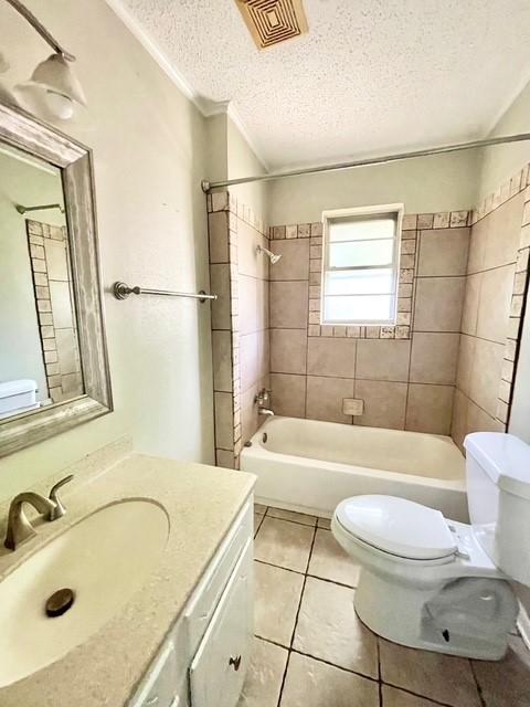 bathroom featuring a textured ceiling, visible vents, toilet,  shower combination, and tile patterned flooring