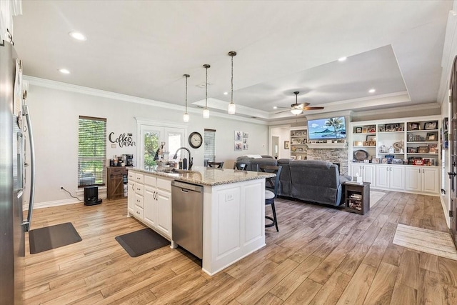 kitchen with light wood-type flooring, a raised ceiling, appliances with stainless steel finishes, and crown molding