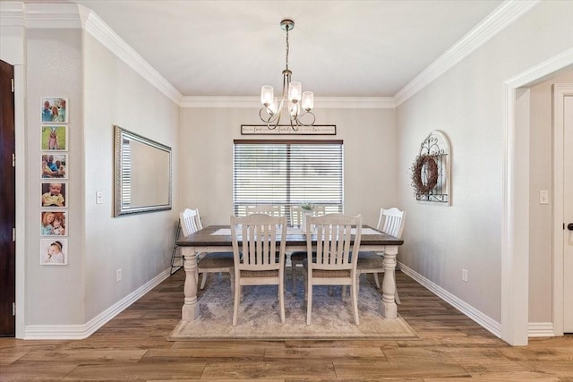 dining room featuring wood finished floors, a chandelier, and baseboards