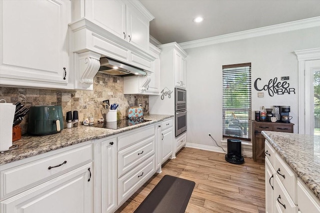 kitchen featuring stainless steel appliances, light wood-type flooring, tasteful backsplash, white cabinetry, and ornamental molding
