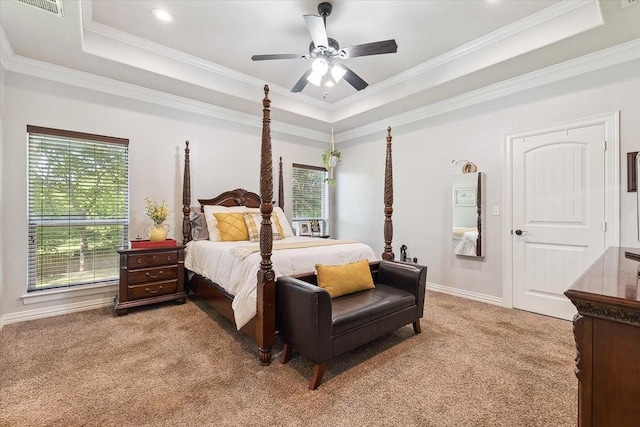 bedroom with a raised ceiling, light carpet, ornamental molding, and multiple windows
