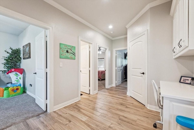 home office featuring crown molding, light wood-style flooring, and baseboards