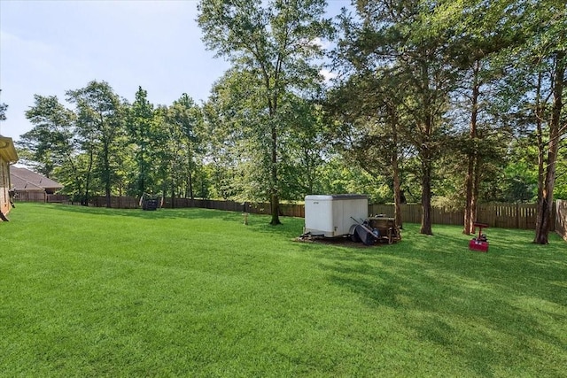 view of yard with a fenced backyard, a shed, and an outdoor structure