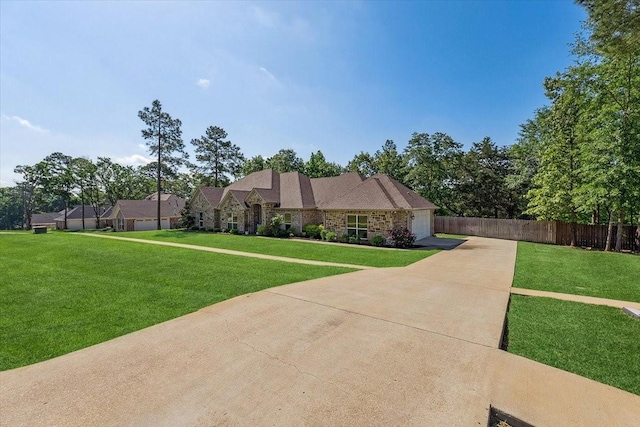 view of front facade featuring fence, concrete driveway, a front lawn, and a garage