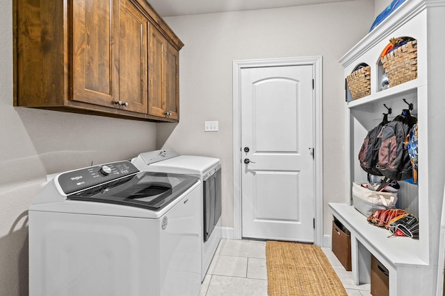 150 Cherokee Hills Ln, Abilene, TX 79606 - laundry area with light tile patterned floors, washing machine and clothes dryer, cabinet space, and baseboards
