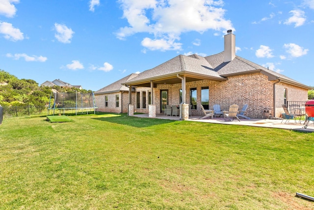 150 Cherokee Hills Ln, Abilene, TX 79606 - back of property with a patio, a trampoline, a chimney, and brick siding