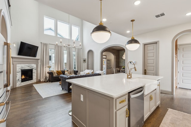 14000 Walsh Ave, Fort Worth, TX 76008 - kitchen with arched walkways, dark wood-style floors, a sink, a high end fireplace, and hanging light fixtures
