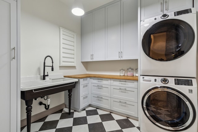 14000 Walsh Ave, Fort Worth, TX 76008 - laundry area with stacked washer / drying machine, cabinet space, and light floors