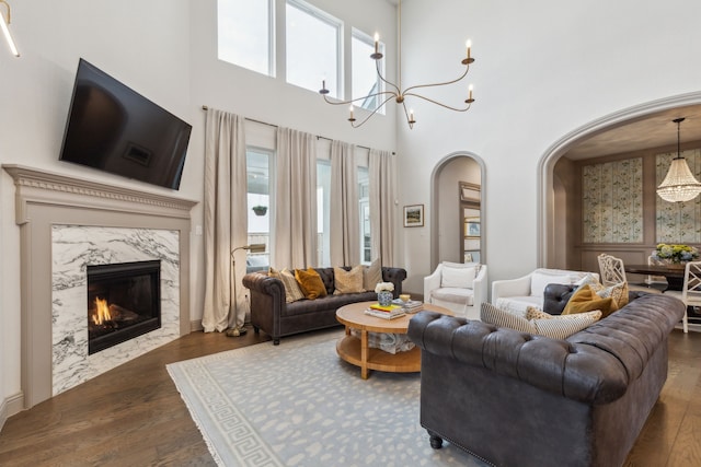 14000 Walsh Ave, Fort Worth, TX 76008 - living area featuring arched walkways, wood finished floors, a chandelier, a towering ceiling, and a high end fireplace