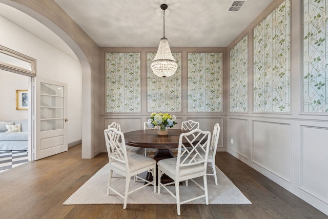 14000 Walsh Ave, Fort Worth, TX 76008 - dining room featuring a decorative wall, arched walkways, dark wood-style floors, and a chandelier