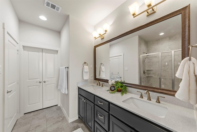 full bath with double vanity, a sink, a shower stall, and visible vents