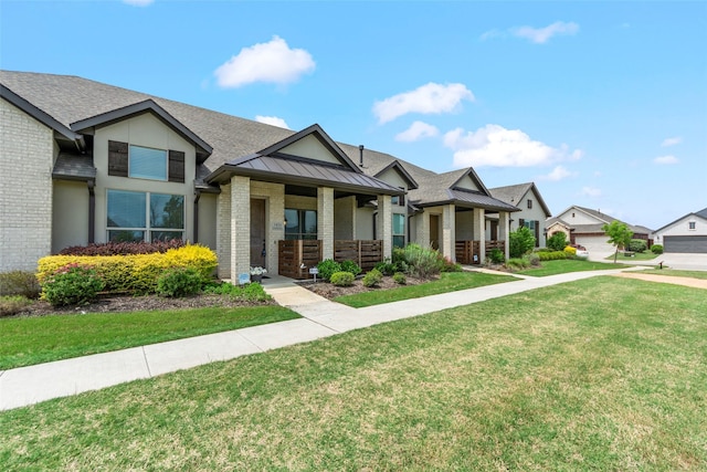 craftsman house with a porch, a front lawn, a standing seam roof, brick siding, and roof with shingles