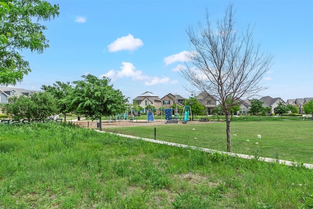 view of home's community with playground community, a yard, and a residential view