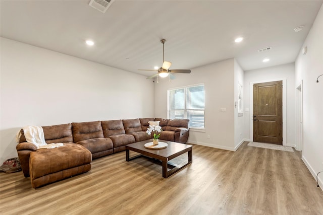 living area with baseboards, visible vents, ceiling fan, and light wood-style floors