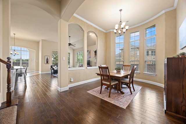 dining area with arched walkways, ceiling fan with notable chandelier, baseboards, a high ceiling, and dark wood-type flooring