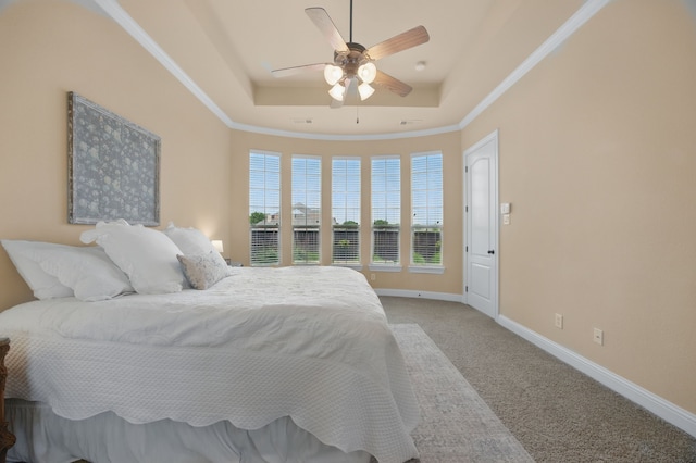 bedroom with light colored carpet, baseboards, a ceiling fan, crown molding, and a tray ceiling