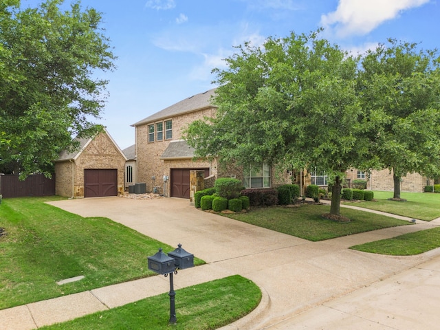 view of front of home with a front lawn, central AC unit, driveway, brick siding, and fence