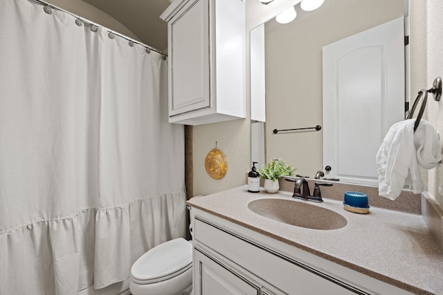 full bathroom with vanity, toilet, and curtained shower