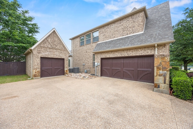 view of front of property featuring fence, a shingled roof, brick siding, and a garage