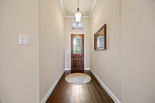 doorway with a textured wall, crown molding, dark wood-style floors, and baseboards