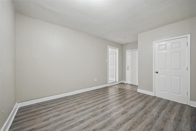 unfurnished bedroom featuring wood finished floors and baseboards